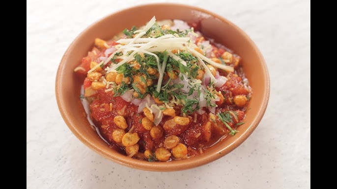 A flavorful street delicacy known for its perfect mix of tangy, spicy, and sweet elements, featuring crispy items topped with chutneys and curd.